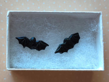 Load image into Gallery viewer, One pair of flat backed bat earrings with relief sculpted detail. Stud earrings are displayed in a white paper jewelry box.