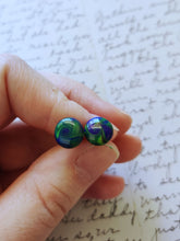 Load image into Gallery viewer, Yellow, blue, and purple swirl earrings held between finger and thumb
