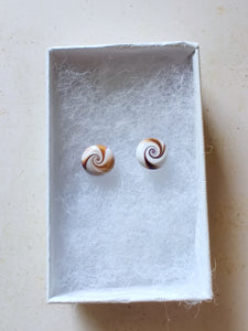 Purple, gold and white swirl earrings inside a white paper jewelry box