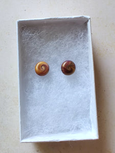 Gold and purple swirl earrings inside a white paper jewelry box