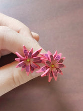 Load image into Gallery viewer, Pink and purple aster flower shaped stud earrings held between finger and thumb
