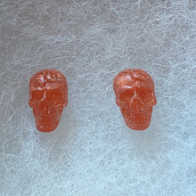 Load image into Gallery viewer, Skull stud earrings in a translucent copper color. 
