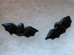 A close up detail picture of one pair of flat backed bat earrings with relief sculpted detail.