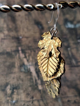 Load image into Gallery viewer, One dangle earring with fall leaves cascading down as if stacked on top of each other. A maple leaf is on top, followed by a beech, an aspen, and a oak.

