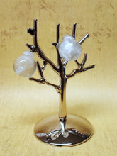 Load image into Gallery viewer, Two miniature Christmas ornament baubles in a clear color with silvery white swirls inside. The earrings are shown before being attached to hooks, and are hanging on a small, silver, leafless tree stand. 
