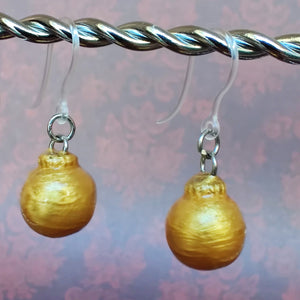 One pair of miniature gold baubles with a reflective textured surface. 