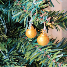 Load image into Gallery viewer, One pair of miniature gold baubles with a reflective textured surface. The earrings are shown hanging from an artificial Christmas tree branch.
