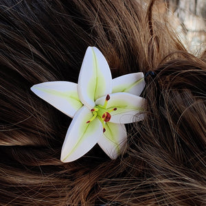 A top view of a white lily pin in a blond hairstyle. 